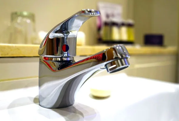 Miscelatore monocomando cromato installato su un lavabo bianco